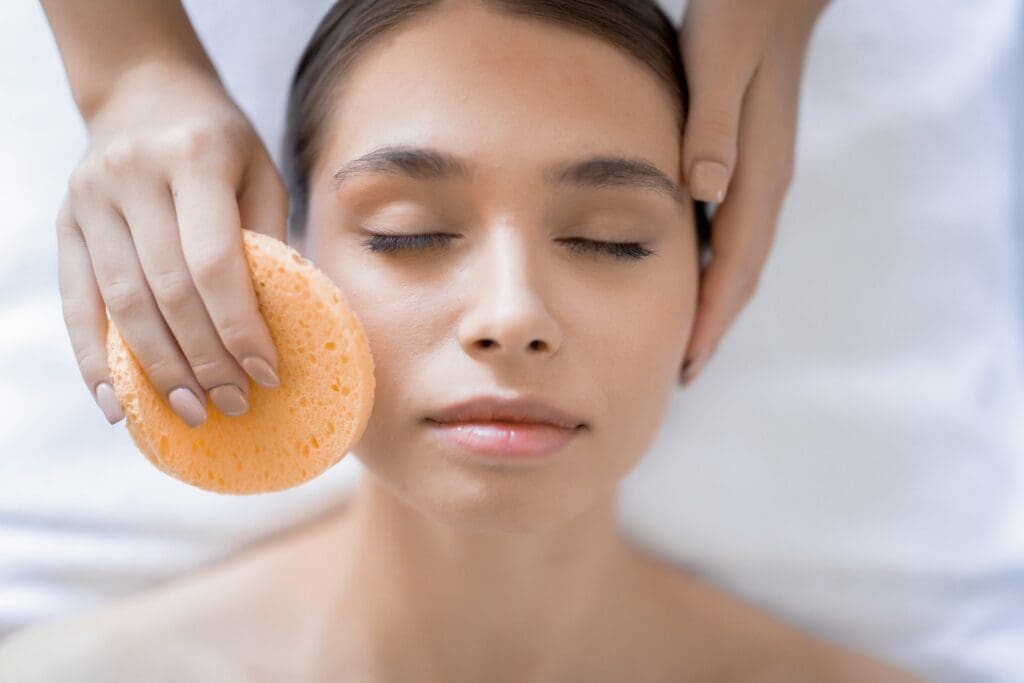 Calm female having peeling-off procedure on her face in beauty salon