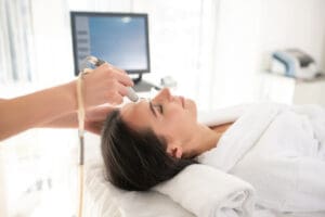 Dark-haired woman laying on the couch having laser skin